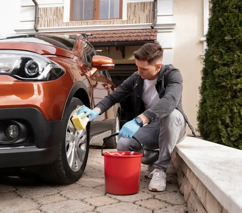 Lavage auto à domicile Novillard : professionnel intervenant sur un véhicule
